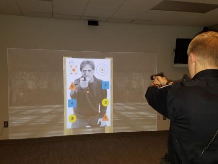 A law enforcement officer uses a simulator for target practice. 