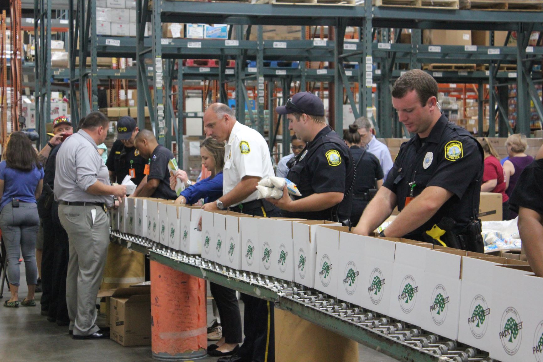 Police officers and volunteers contributing to Greg's Groceries